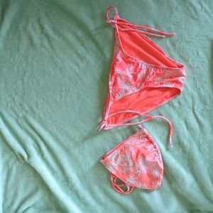 A Hawaiian print matching bright peach and white bikini top and bottom set